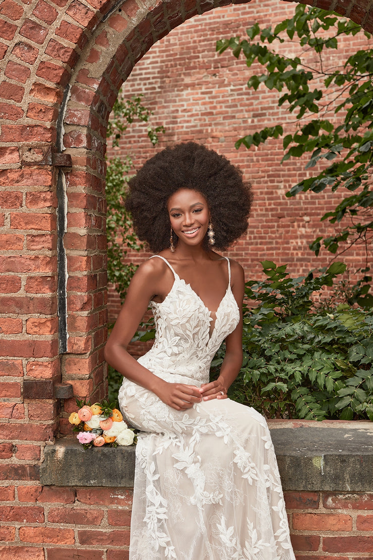 Rustling leaves and delicate branches arch across the bodice of our strappy Jordan sheath, leading to a Chantilly lace train.