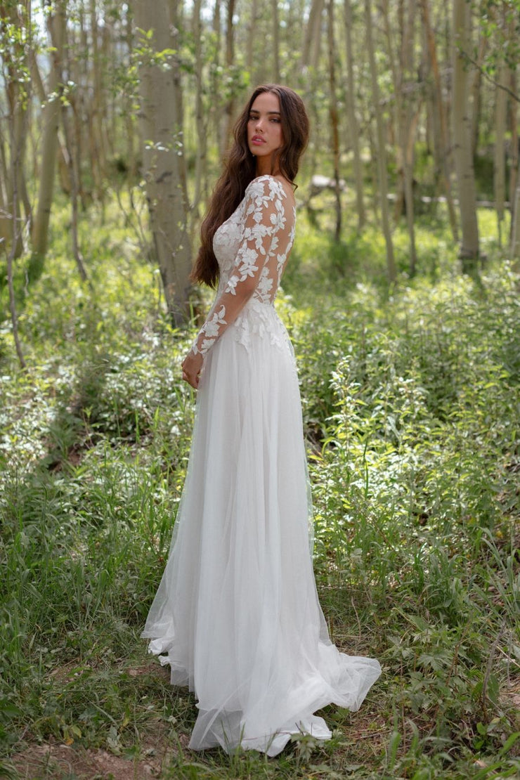 Romantic lace leaves and flowers scatter across the illusion sleeves and bodice of this A-line gown.